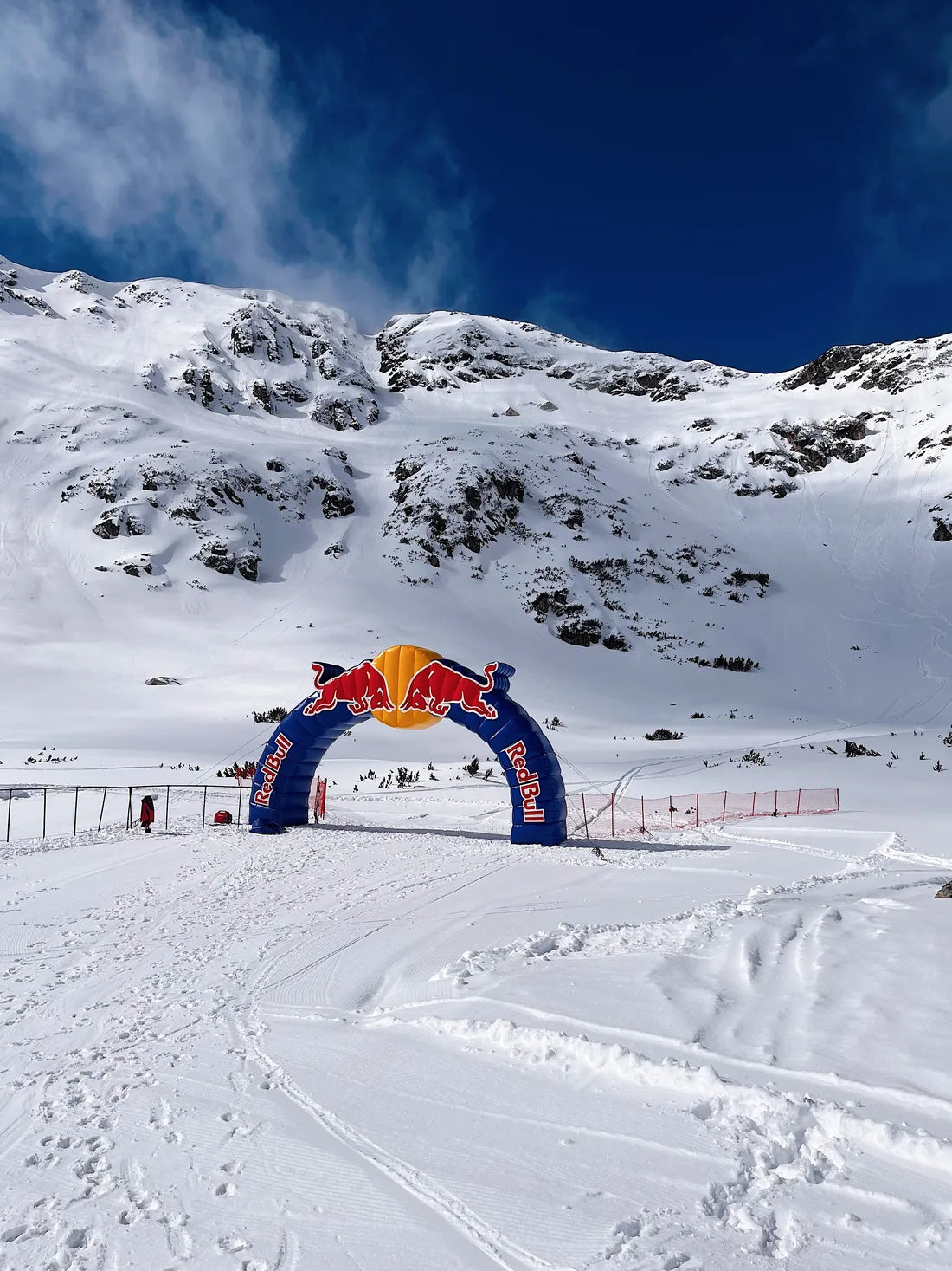 A solitary Red Bull arch amid snow and mountains in Bansko